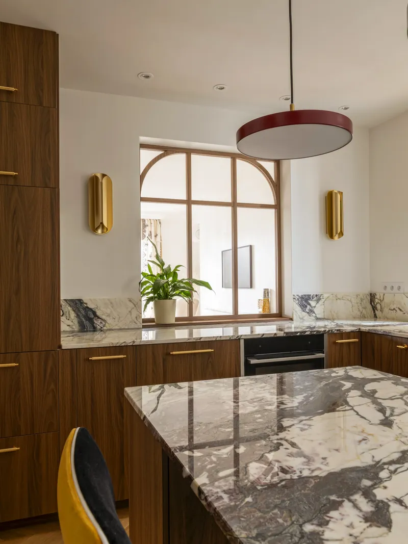 Cuisine avec îlot en marbre et rangements en noyer, appartement de 90 m² à Paris 17e, projet Charles Fillon